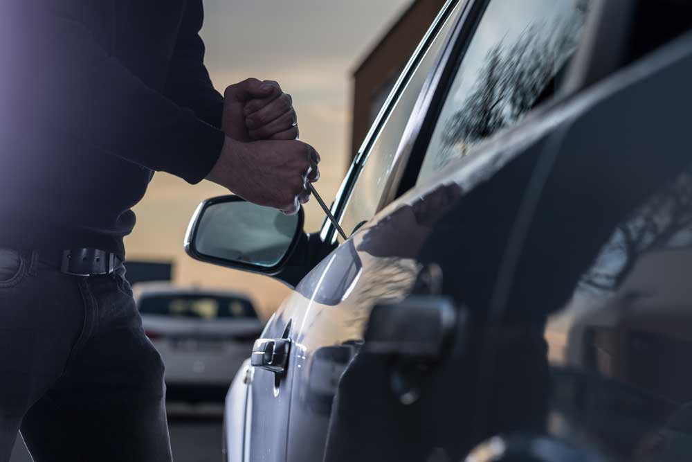Dief probeert in te breken in auto.