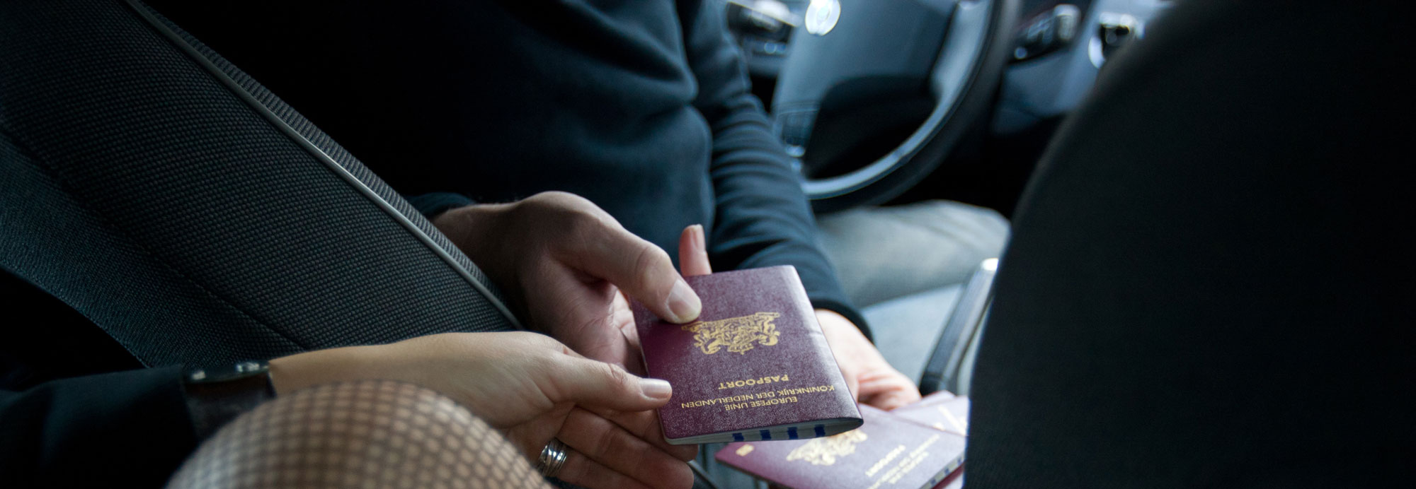 Vrouw geeft paspoort aan man. Ter illustratie van het CCV-dossier Seksuele uitbuiting.