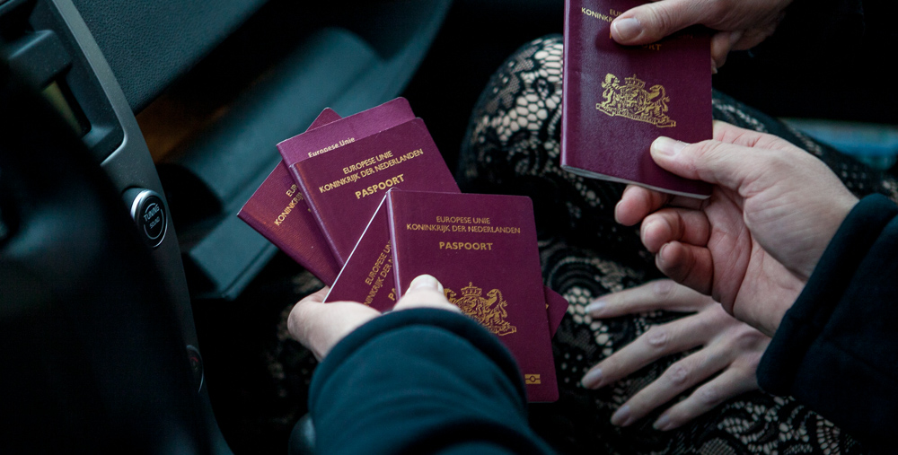 Foto van paspoorten die ingenomen worden door een persoon. Ter illustratie van het CCV-dossier Mensenhandel.