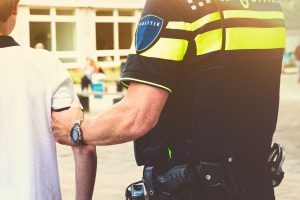 Jongen wordt gearresteerd door een agente - illustratie in het dossier wapens en jongeren van het CCV.