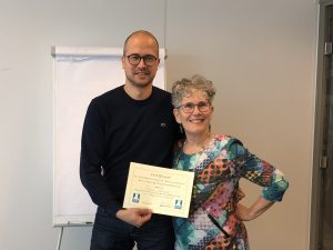 CCV-adviseur Sten Meijer (links) met voorzitter Frieda Boekel van de Adviescommissie Buurtbemiddeling. Hij toont het certificaat dat Buurtbemiddelaars ontvangen als ze de basistraining hebben gehaald.