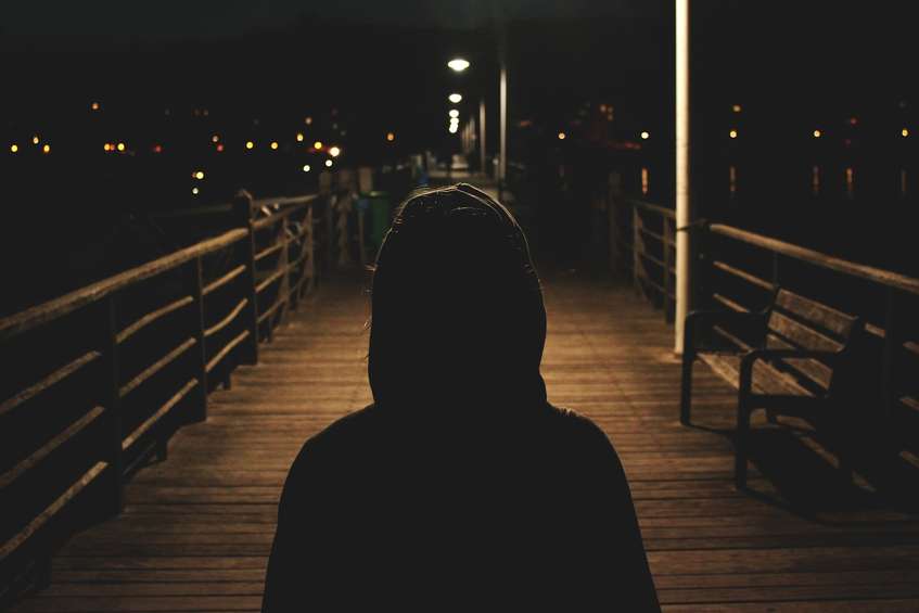 Jongere loopt in het donker met hoodie aan. Ter illustratie van het dossier Veiligheid en Zorg van het CCV.