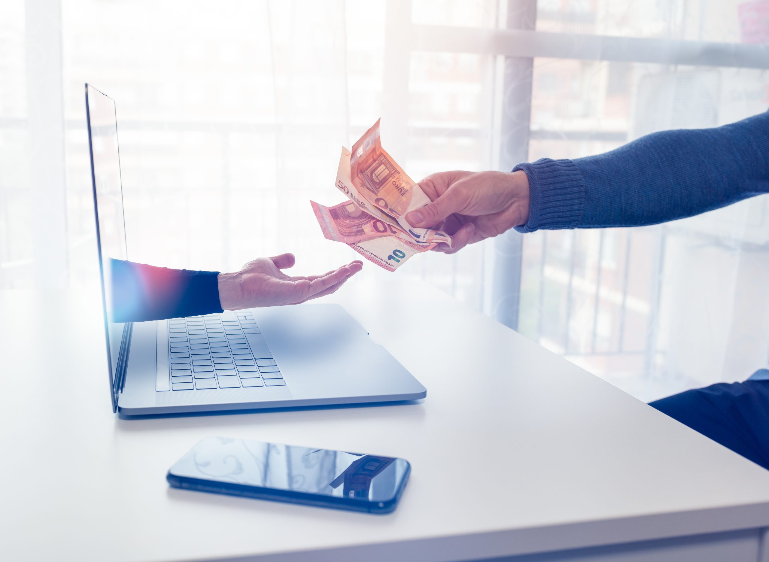 hand uit laptop krijgt geld