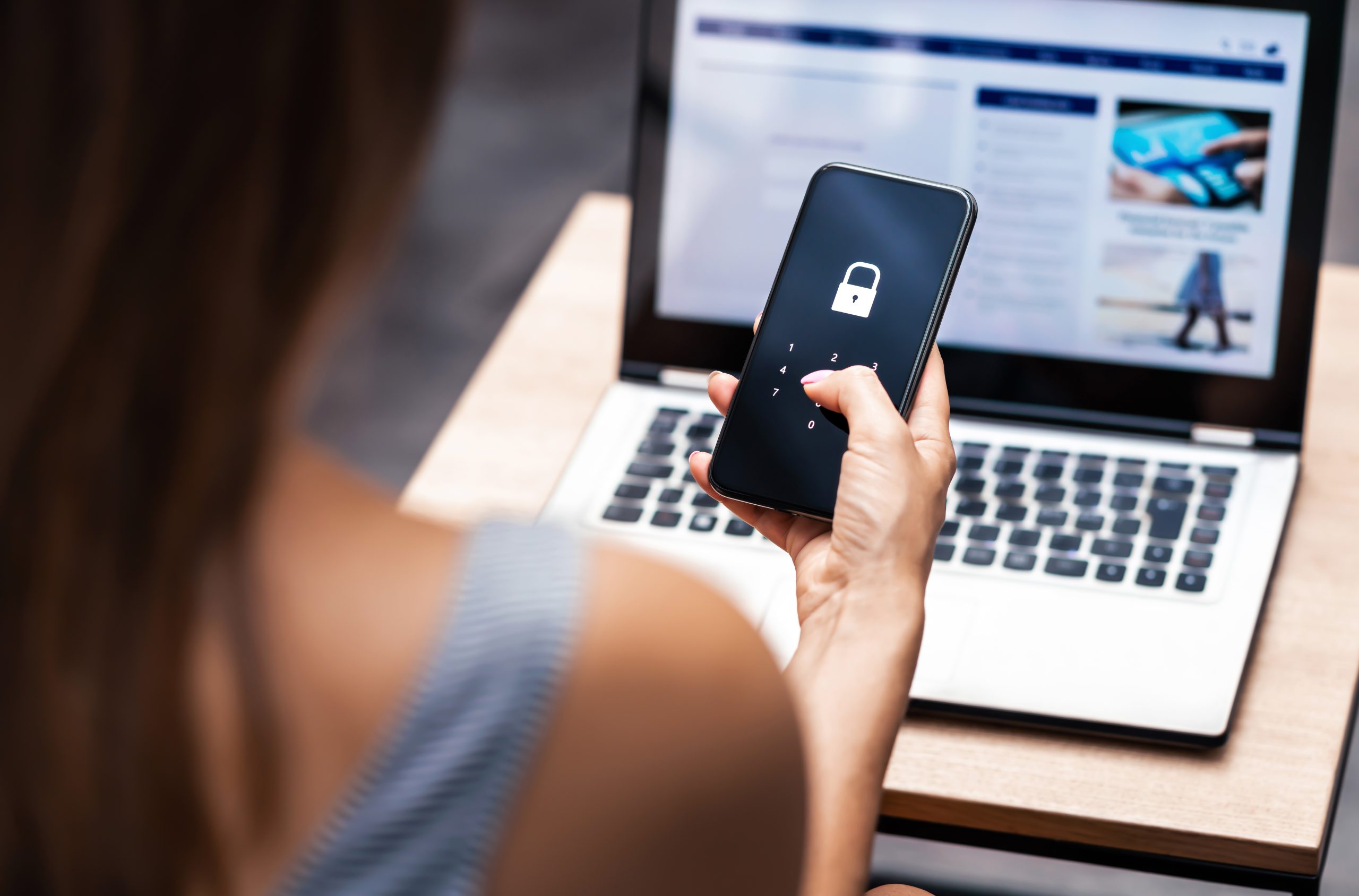 vrouw met telefoon voor laptop