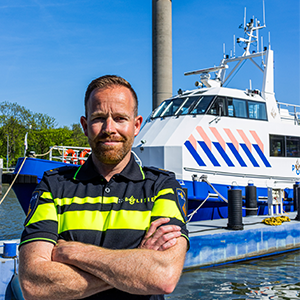 Ronald Heesbeen voor een politieboot. Hij is voormalig projectleider en mede-initiatiefnemer vanuit de Zeehavenpolitie,
